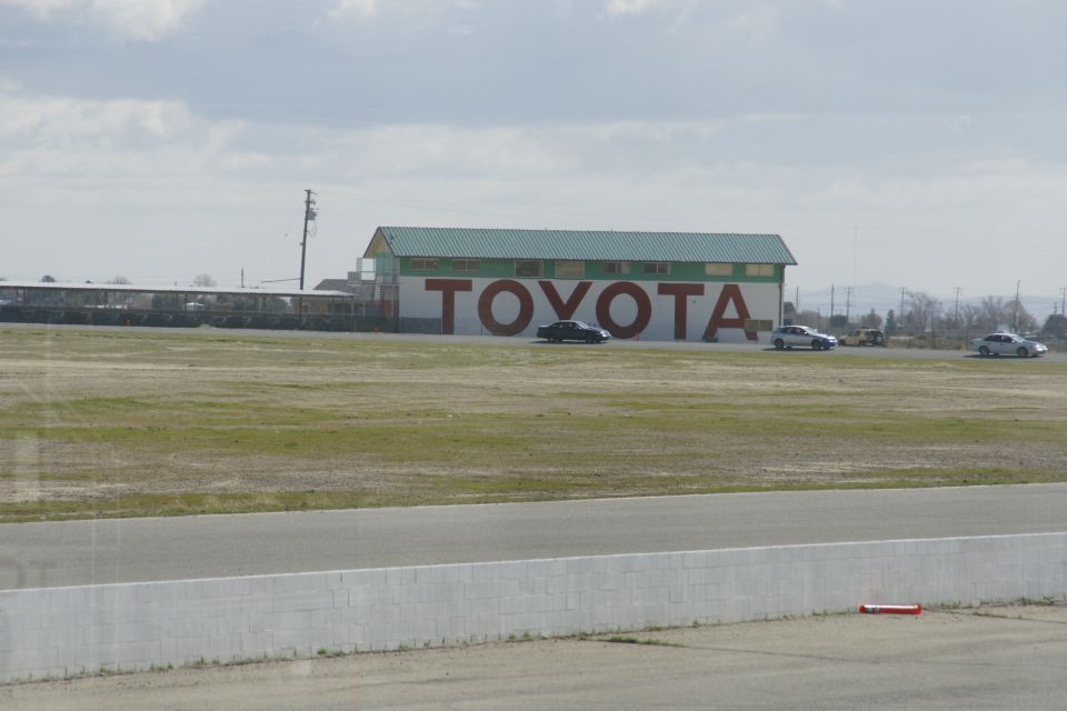 Toyota building with cars on a track, overcast sky