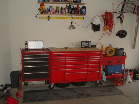 1989 Ford Bronco - A well-organized garage workbench area with multiple tool chests and supplies neatly arranged on shelves.