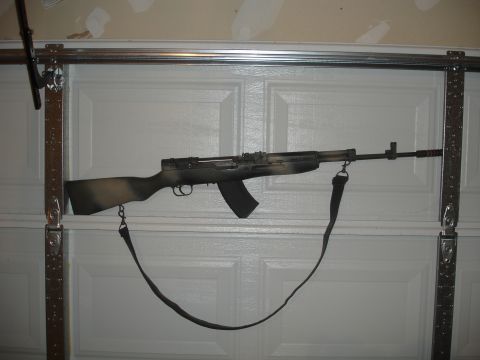 1989 Ford Bronco - A camouflage-painted rifle is mounted on a sectional garage door.