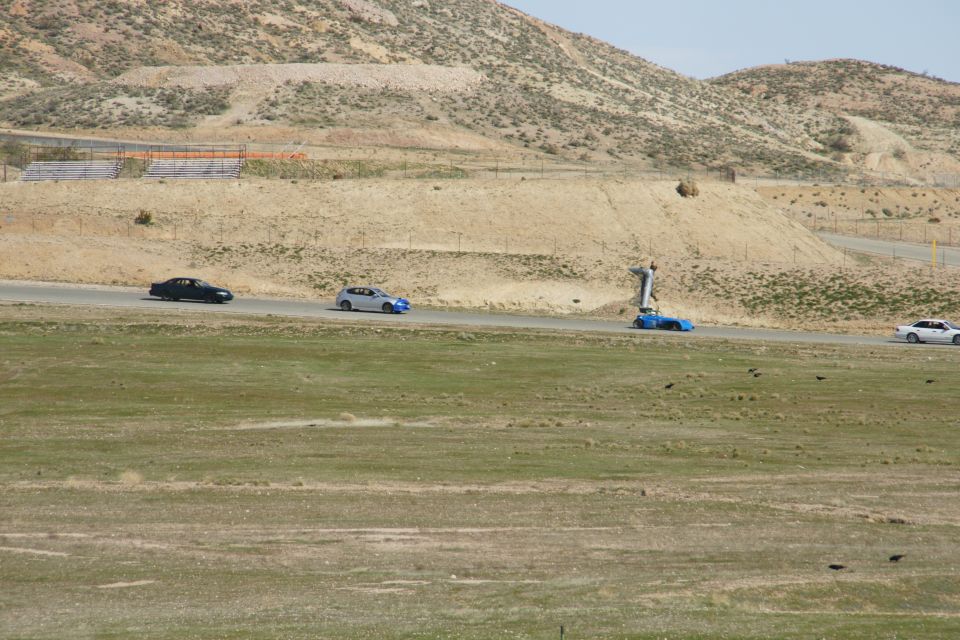 Cars driving on a road with hills in background