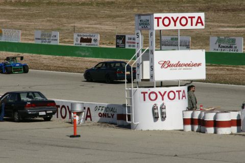 1995 Ford Taurus - A race track scene multiple vehicles and sponsor signage, including Toyota and Budweiser.
