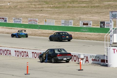 1995 Ford Taurus - A race track scene with multiple vehicles, including a car with its door open.