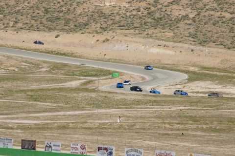 1995 Ford Taurus - Multiple vehicles navigate a challenging race track under a clear sky.