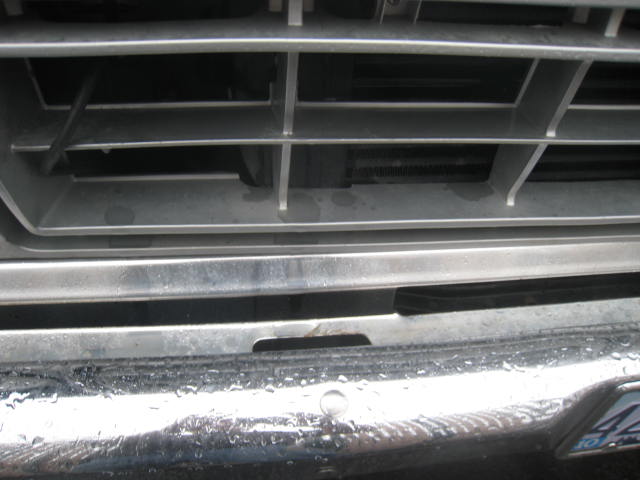 Close-up of a silver grille and chrome bumper of an older truck