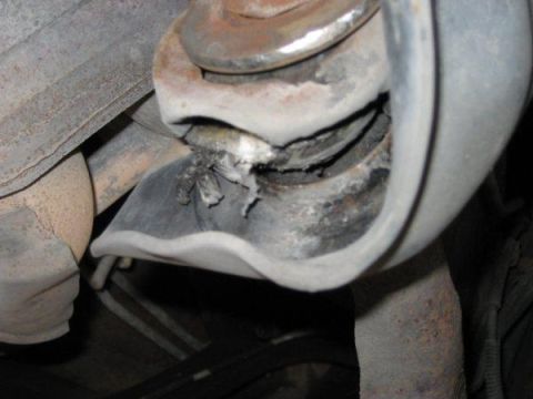 1996 Ford Bronco - Close-up of a damaged exhaust hanger, showing the torn rubber and metal components.