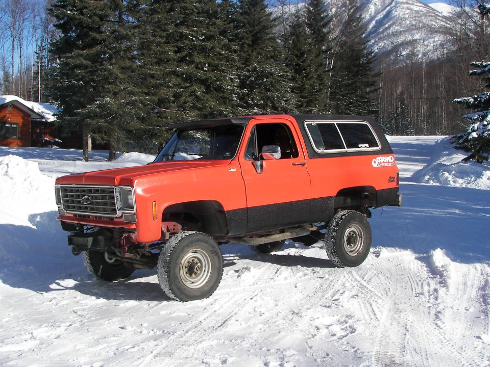 Orange and black lifted SUV with off-road decal, side view