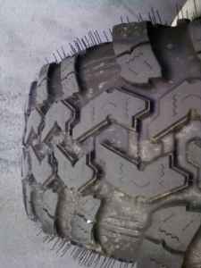 1990 Ford Bronco - Close-up of a tire tread with the Supermotors.net watermark.
