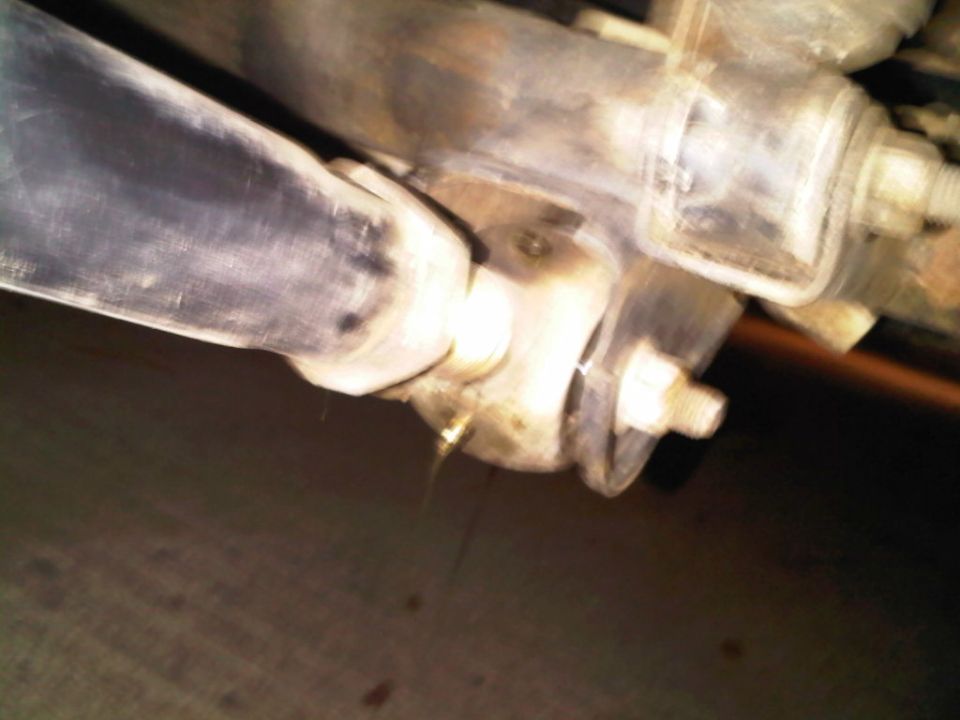 Blurry underbody close-up of a leaf spring end, shackle bracket and mounting bolts