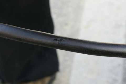 1995 Ford Taurus - A close-up view of a damaged black hose with visible cracks and wear.