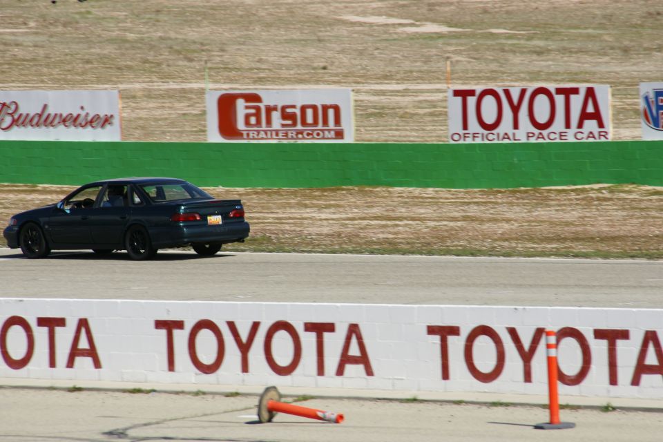 Dark sedan on race track, rear view