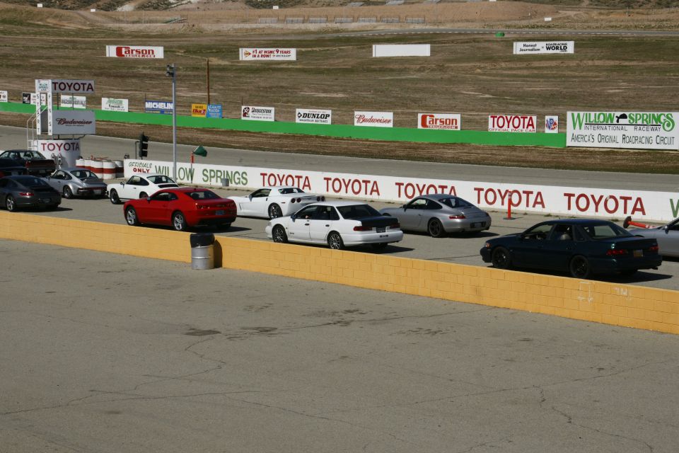 Cars lined up on a race track with Toyota and Willow Springs signage