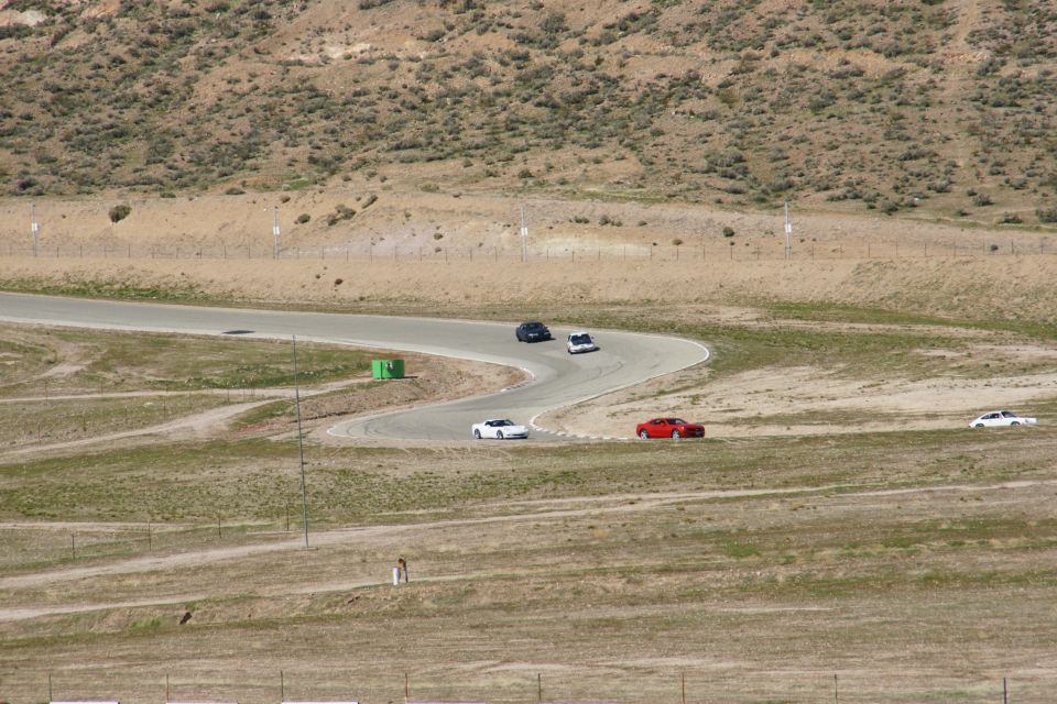 Red sports car and other vehicles on a winding race track