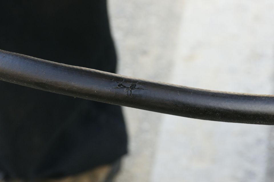 Close-up of a black hose with a cracked and damaged section