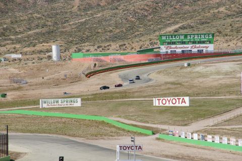 1995 Ford Taurus - Multiple vehicles race on a track at Willow Springs International Raceway.