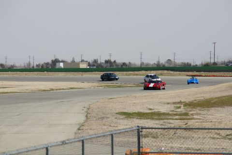1995 Ford Taurus - Multiple vehicles compete on a race track, with a red and white car in the foreground.