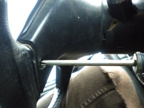 1989 Ford Bronco - A screwdriver is shown inserted into the steering wheel column of a vehicle.