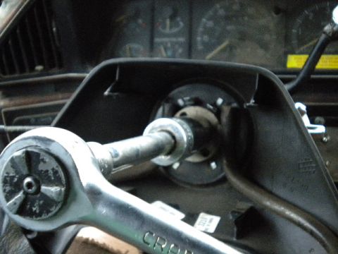 1989 Ford Bronco - A socket wrench is being used on the steering column of a vehicle, with the dashboard gauges in the background.