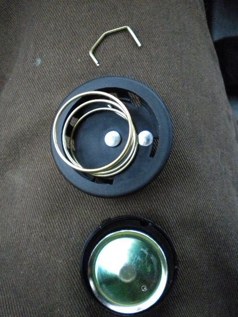 1989 Ford Bronco - Disassembled steering wheel hub components are laid out on a brown fabric surface.