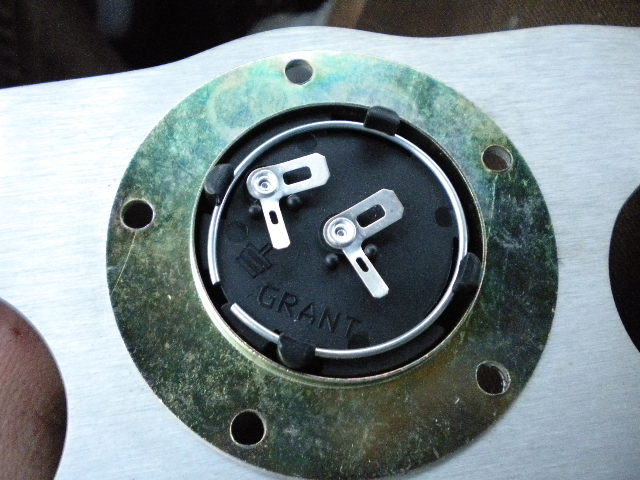 Back of Grant steering wheel hub with horn contacts and 'GRANT' text on aluminum plate