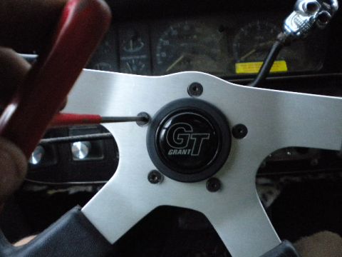 1989 Ford Bronco - Installing a Grant GT steering wheel, adjusting the center cap screw with a red screwdriver.