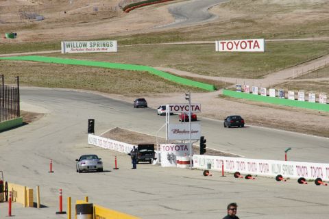 1995 Ford Taurus - Cars on a race track with various sponsor signs, including Toyota and Willow Springs.