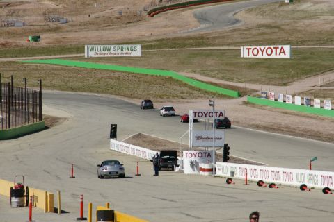 1995 Ford Taurus - Cars race on a track with various sponsor signs in the background.