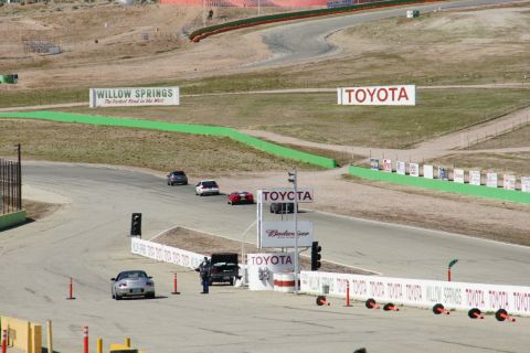 1995 Ford Taurus - Cars race on a track with prominent Toyota and Willow Springs signage visible.