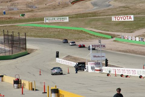 1995 Ford Taurus - Cars on a race track at Willow Springs, with Toyota signage in the background.