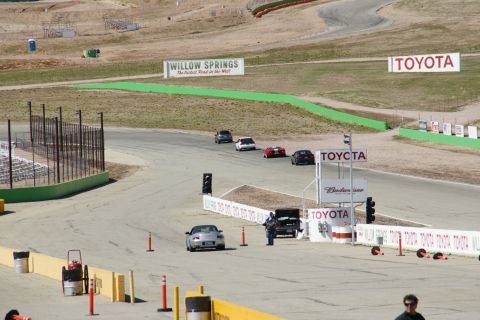 1995 Ford Taurus - Several cars are on a race track, with various sponsor signs visible in the background.