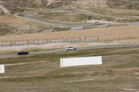 1995 Ford Taurus - Two sedans navigate a challenging road course under a clear sky.