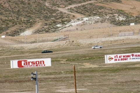 1995 Ford Taurus - Two cars are seen on a race track, with advertising banners visible in the foreground.