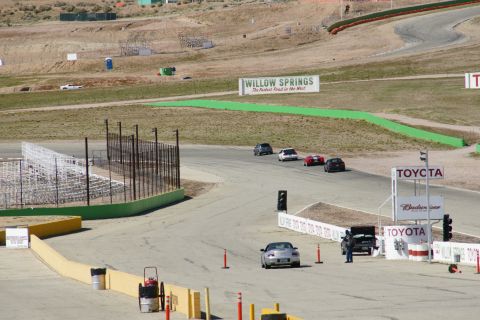 1995 Ford Taurus - Multiple cars are seen racing on a track at Willow Springs.