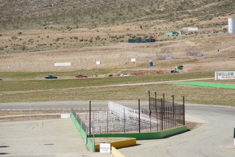 1995 Ford Taurus - A racetrack scene with multiple vehicles visible on the track and surrounding terrain.