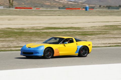 1995 Ford Taurus - A yellow and blue race car is seen on a track from the side.