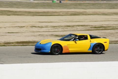 1995 Ford Taurus - Sports car with taped sections on track, driver wearing helmet.
