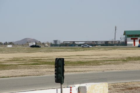 1995 Ford Taurus - A black sedan and a white sedan are seen on a race track, with a traffic light visible in the foreground.