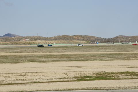 1995 Ford Taurus - Multiple vehicles are visible on a wide, open racetrack with distant hills.