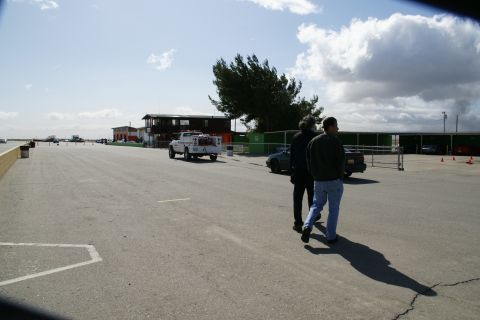1995 Ford Taurus - A sunny day at a track with people and vehicles present.