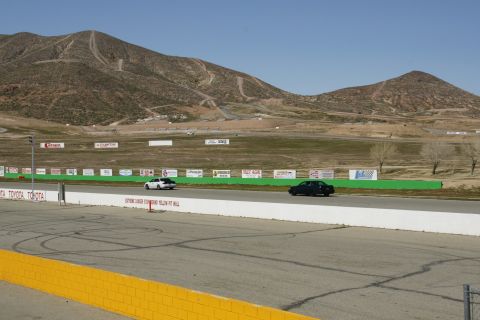 1995 Ford Taurus - Cars on a racetrack with mountains behind them. Toyota signage visible.