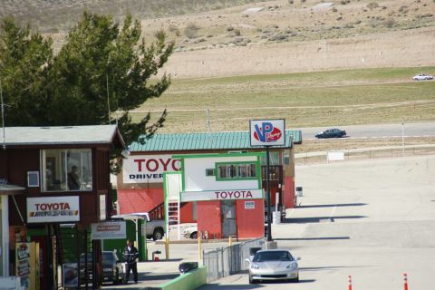 1995 Ford Taurus - A view of a Toyota Driver school facility at a racetrack, with several cars visible on the track and in the foreground.