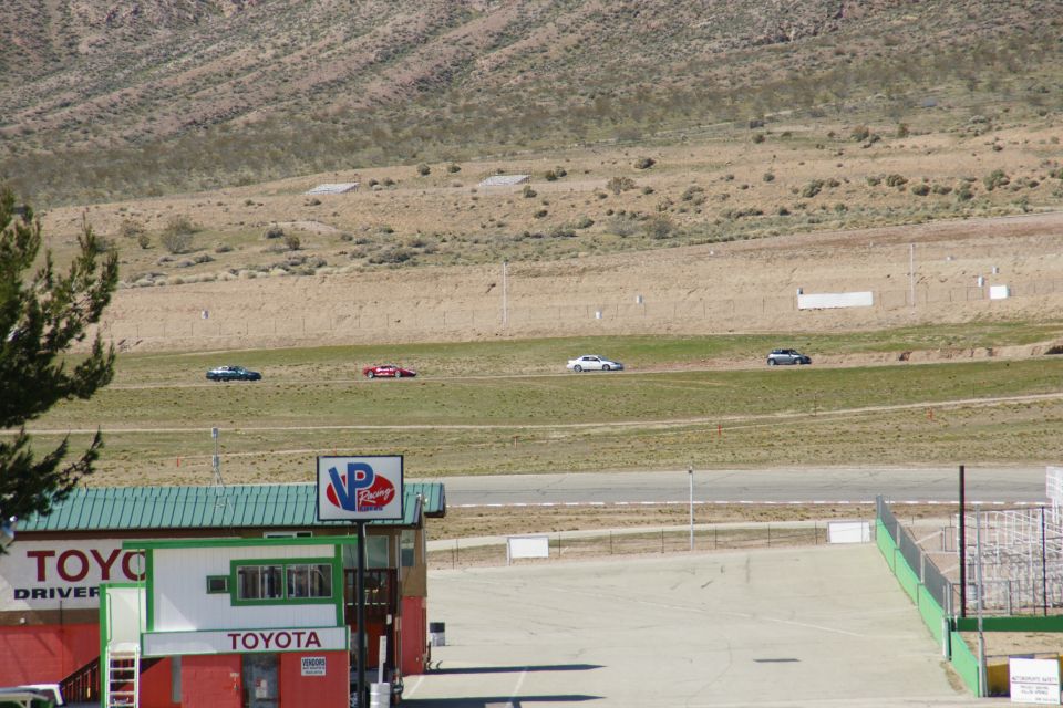 Cars on a race track with a Toyota building in the foreground