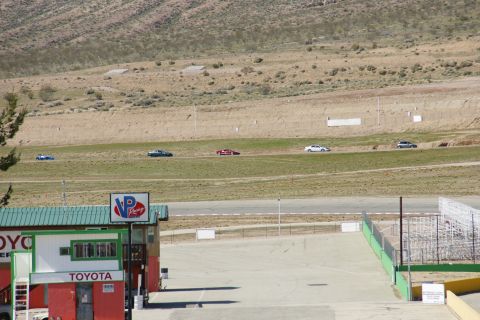 1995 Ford Taurus - Cars race on a track with a building and grandstands visible.