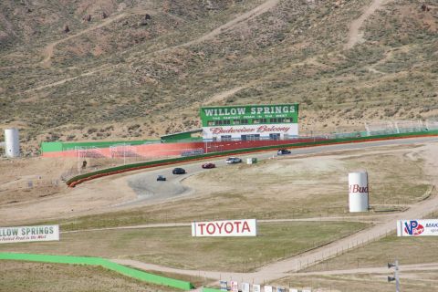 1995 Ford Taurus - Race cars compete on the Willow Springs International Raceway circuit, with the iconic Willow Springs sign and Budweiser Balcony visible in…