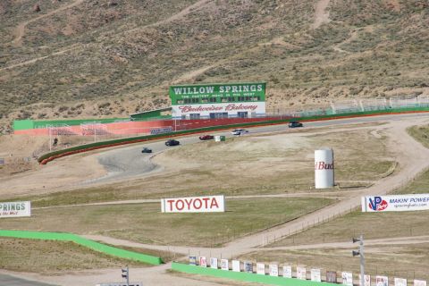 1995 Ford Taurus - Several cars are racing on a track with a large Willow Springs sign and Budweiser balcony in the background.