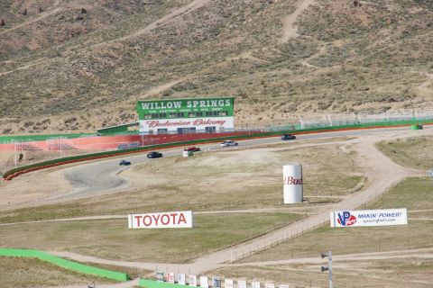 1995 Ford Taurus - Cars race on a track with a Budweiser tower and various signs in the background.