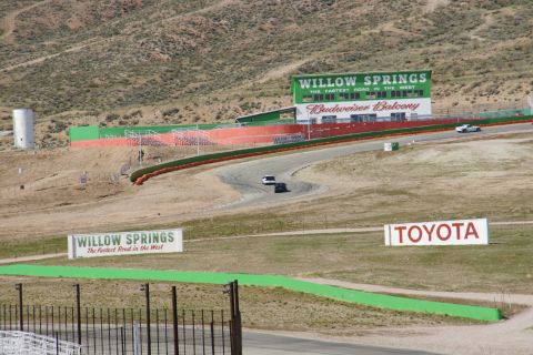1995 Ford Taurus - A race track scene at Willow Springs International Raceway features two cars on the track, with prominent signage for Willow Springs and To…