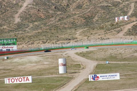 1995 Ford Taurus - Two cars race on a track with sponsor signage in the background.