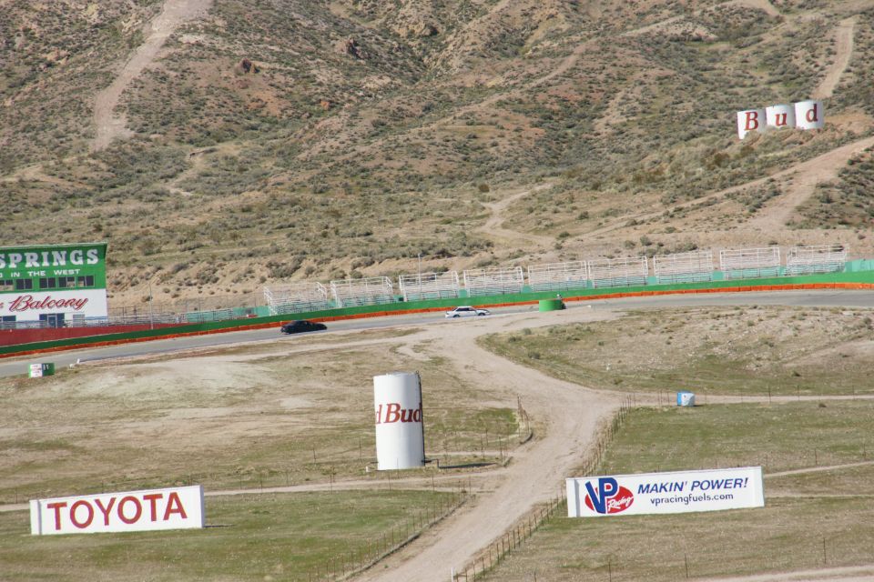 Cars on a race track with Budweiser and Toyota signs visible