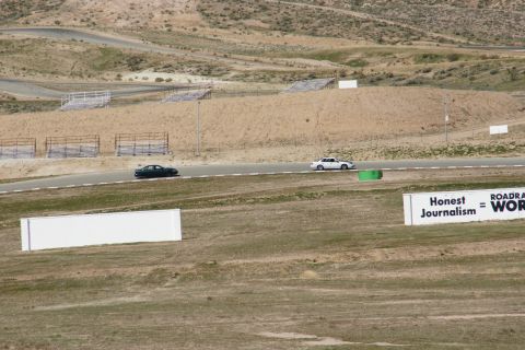 1995 Ford Taurus - Two sedans race on a track with grandstands in the background and a sign that reads 'Honest Journalism = WORK'.