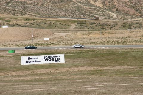 1995 Ford Taurus - Two cars are driving on a race track with a sign that reads "Honest Journalism = ROADRACING WORLD.com" in the foreground.